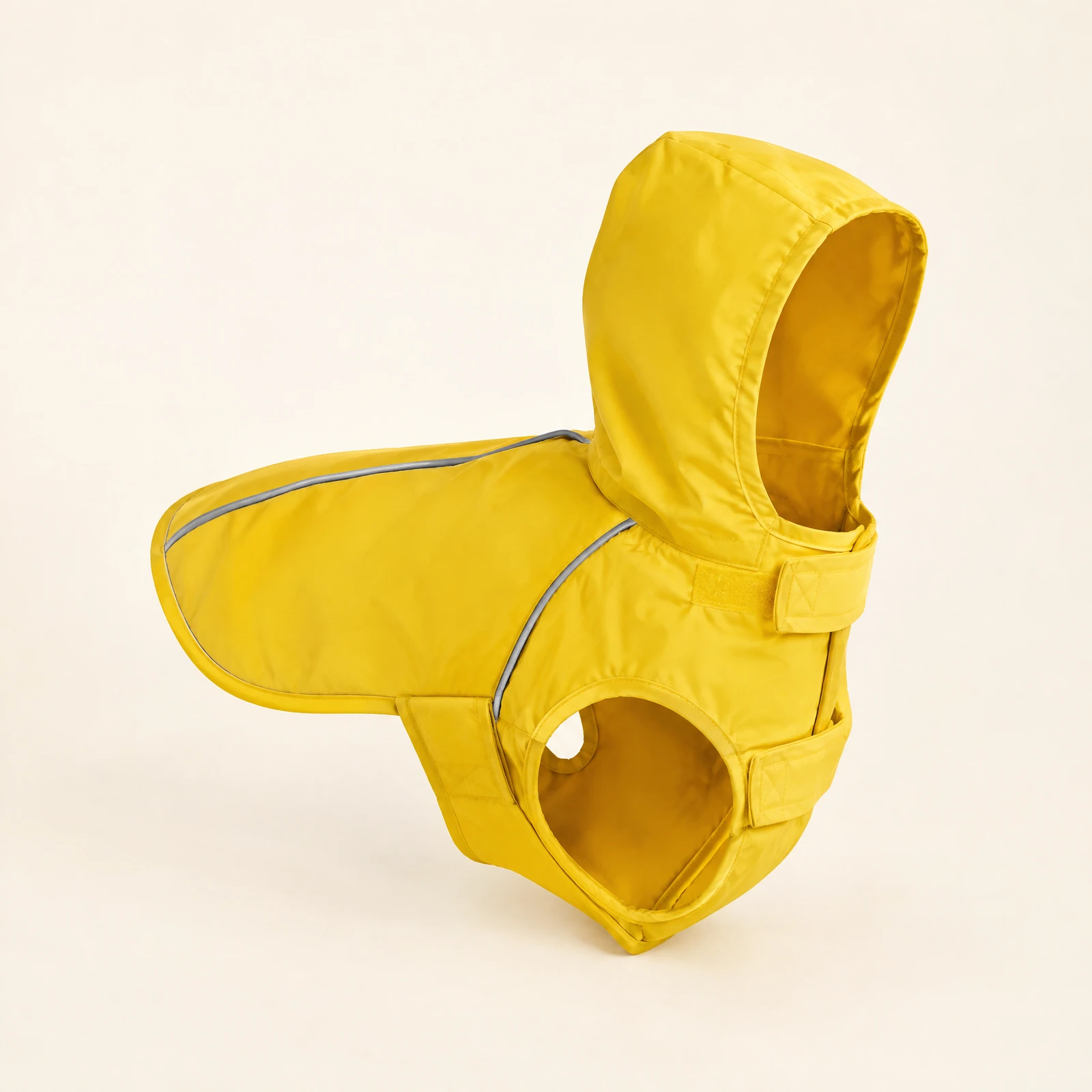 A yellow hooded dog jacket with reflective piping and hook-and-loop straps, shown as a ghost-mannequin style product photo on a cream background